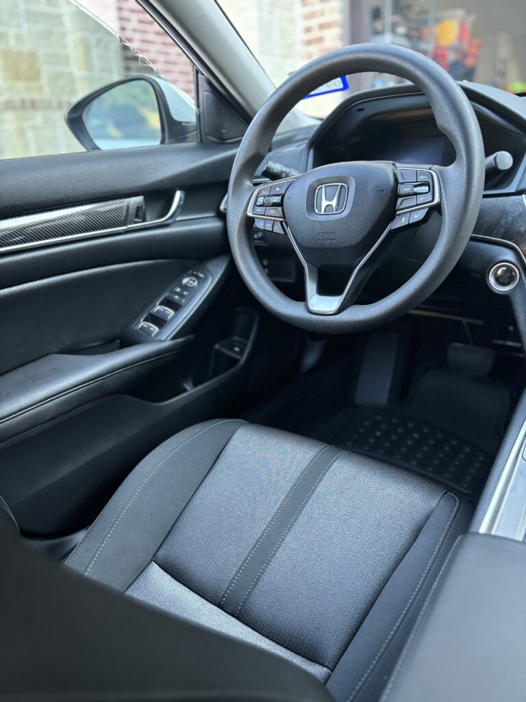 Immaculately cleaned car interior with spotless seats, dashboard, and floor mats.